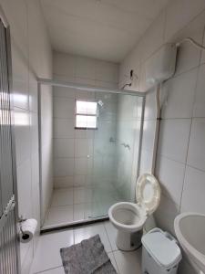 een badkamer met een douche, een toilet en een wastafel bij Pousada JM in Parque Dom Bosco