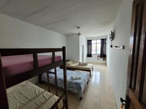 a room with two bunk beds and a hallway at Pousada JM in Parque Dom Bosco