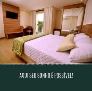 a bedroom with a large bed and a desk at Cond Vista Azul in Pedra Azul