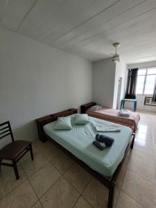 a bedroom with two beds and a chair in it at Pousada JM in Parque Dom Bosco +23 photos
