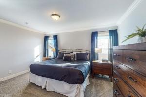 Schlafzimmer mit einem Bett, einer Kommode und Fenstern in der Unterkunft Quail Nest on Quail Drive in Fraser