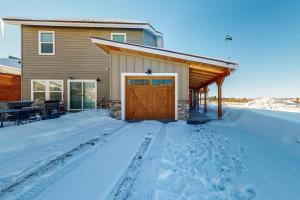 ein Haus mit einer Holzgarage im Schnee in der Unterkunft Quail Nest on Quail Drive in Fraser