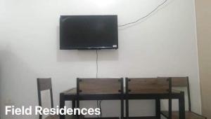 a flat screen tv hanging on a wall above a table at Field Residences in Manila