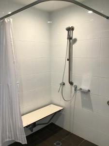 baño con cabina de ducha con banco en Leumeah Lodge en Canberra