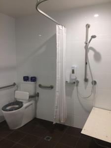 a bathroom with a toilet and a shower at Leumeah Lodge in Canberra