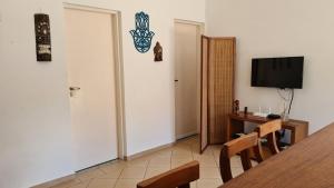 マレシアスにあるFlat 47 SUN HOUSE Maresiasのテーブルとテレビ付きのドアが備わる部屋