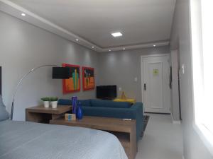 ポルト・アレグレにあるApt excelente local Consulado/Iguatemiのリビングルーム(青いソファ、テレビ付)