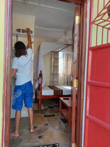 a person reaching up to a bed in a room at Amarrosi Lion - Studio terrace Apartment ,Mtwapa in Mtwapa