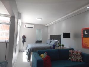 a bedroom with a bed and a blue couch at Apt excelente local Consulado/Iguatemi in Porto Alegre