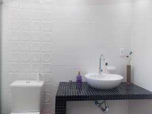 a white bathroom with a sink and a toilet at Apt excelente local Consulado/Iguatemi in Porto Alegre