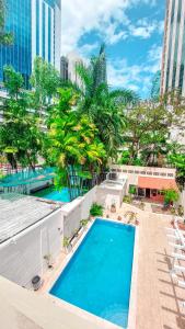 une grande piscine avec des palmiers et des bâtiments dans l'établissement Bodhi Panama City, à Panama City