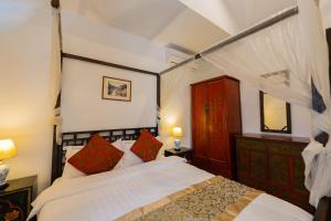 a bedroom with a canopy bed with red pillows at BTC Boutique Resort Private Pool Villas and Studios Hua Hin บ้านทะเลจีน บูติค รีสอร์ท หัวหิน in Hua Hin +121 photos