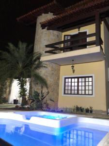 une maison avec une piscine en face d'une maison dans l'établissement Casa de praia, piscina aquecida, cervejeira e bilhar, à Bertioga