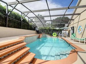a swimming pool with a glass roof on a house at Flounder Vacation Home in Orlando