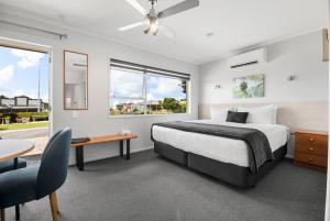 1 dormitorio con cama, escritorio y ventana en Te Aroha Motel, en Te Aroha