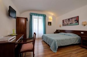 a bedroom with a bed and a desk with a computer at Vatican Rooms D’Angelica in Rome