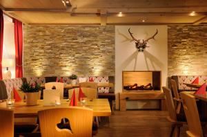 un restaurante con mesas de madera y chimenea en Hirsch - Das Ellwanger Landhotel, en Ellwangen
