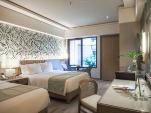 um quarto de hotel com duas camas e uma secretária em Henann Park Resort em Boracay