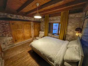 a bedroom with a bed in a room with wooden walls at Keyifli Bir Taş Ev SAÇAKLIHANE Çanakkale Tavaklı in Ezine