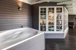 a bath tub in a room with a window at Yallingup Lodge Spa Retreat in Yallingup +50 photos