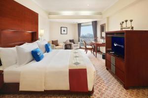 una camera d'albergo con un grande letto e una TV di Hotel Bidakara Jakarta a Giacarta
