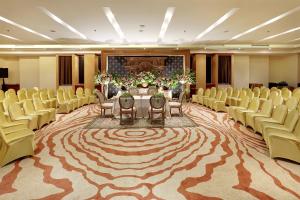 Habitación con mesa, sillas y alfombra grande. en Hotel Bidakara Jakarta en Yakarta