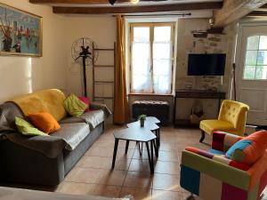 sala de estar con sofá, sillas y TV en Holiday house in the countryside en Taillant