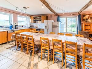 uma cozinha com uma grande mesa de madeira e cadeiras em Beautiful Farmhouse in Brisy with Sauna em Brisy