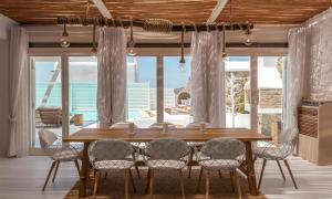 a dining room with a wooden table and chairs at Luxury Ocean View Villa Mykonos Centre in Mikonos