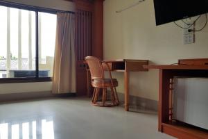 彭世洛Poonsook Phitsanulok Hotel SHA Plus的客房设有书桌、椅子和电视。