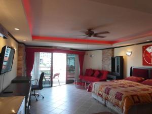 a bedroom with a bed and a couch and a tv at View talay Vt2a F5 R207 in Pattaya South