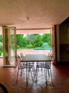 einen Tisch und Stühle in einem Zimmer mit Terrasse in der Unterkunft Finca La Dacha in Villavicencio