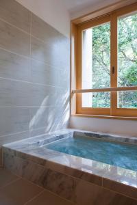 a bath tub in a bathroom with a window at Ikyu in Ise