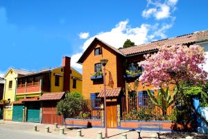 una fila de casas con un árbol floreciente delante en Casa del Arupo, en Quito