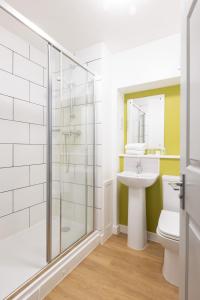 a bathroom with a shower and a toilet and a sink at The Broadway Park Hotel in Sandown