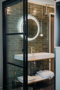 a bathroom with a sink and a mirror at Lillan Hotel & Kök in Tampere