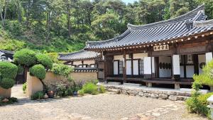 an asian style building in a garden at Tohyang Traditional House in Bonghwa