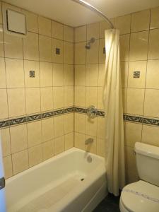 een badkamer met een wit bad en een toilet bij Azusa Inn in La Puente