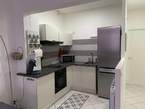 a kitchen with white cabinets and a stainless steel refrigerator at Appartement Bar-le-Duc, 2 pièces, 4 personnes - FR-1-585-77 in Bar-le-Duc