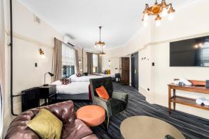 a hotel room with a couch and a bed at Hotel Queanbeyan Canberra in Queanbeyan