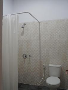 uma casa de banho com um chuveiro e um WC. em Aldeoz Residence Kuta em Kuta