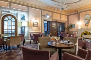 a restaurant with tables and chairs and a fireplace at The Caledonian Island Hotel in Sandown