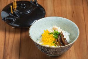 a bowl of food with rice and cheese on a table at KOKO HOTEL Kagoshima Tenmonkan in Kagoshima