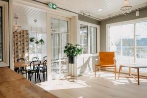 ein Esszimmer mit Tisch, Stühlen und Fenstern in der Unterkunft Lillan Hotel & Kök in Tampere