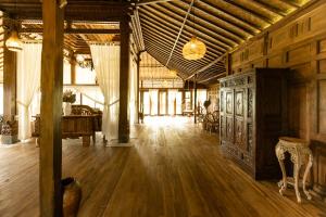 een grote kamer met houten vloeren en een houten plafond bij Tanah Damai Hotel in Nusa Penida