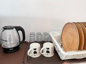 a coffee maker and cups and a rack of dishes at Simfoni Beliza Apartment with Roof Top Pool by Vintage in Kuah