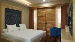 um quarto com uma cama e uma cadeira azul em Aldeoz Residence Kuta em Kuta