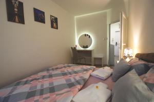 a bedroom with a bed and a desk with a mirror at TOP Apartman in Šabac