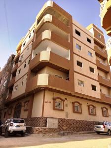 um edifício com carros estacionados em frente em Cozy Apartment Freedom em Hurghada