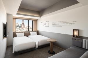 a hotel room with two beds and a table at Bespoke Hotel Sapporo in Sapporo